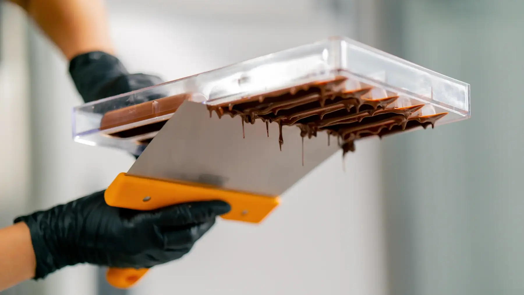 The Chocolate Studio. Scraping a chocolate mould down at the MayHawk Chocolate Studio. Making bean-to-bar chocolate.
